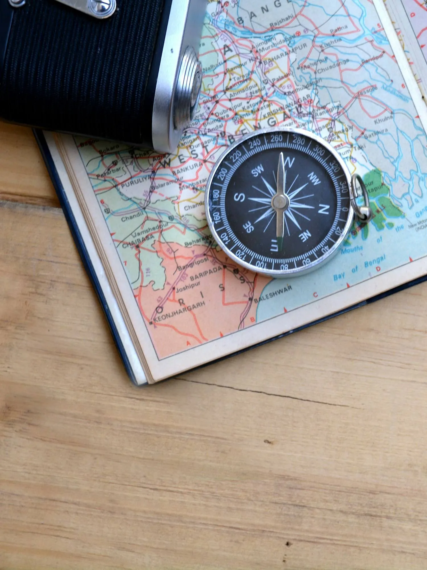 A notebook, camera and bag laid out on a paper map