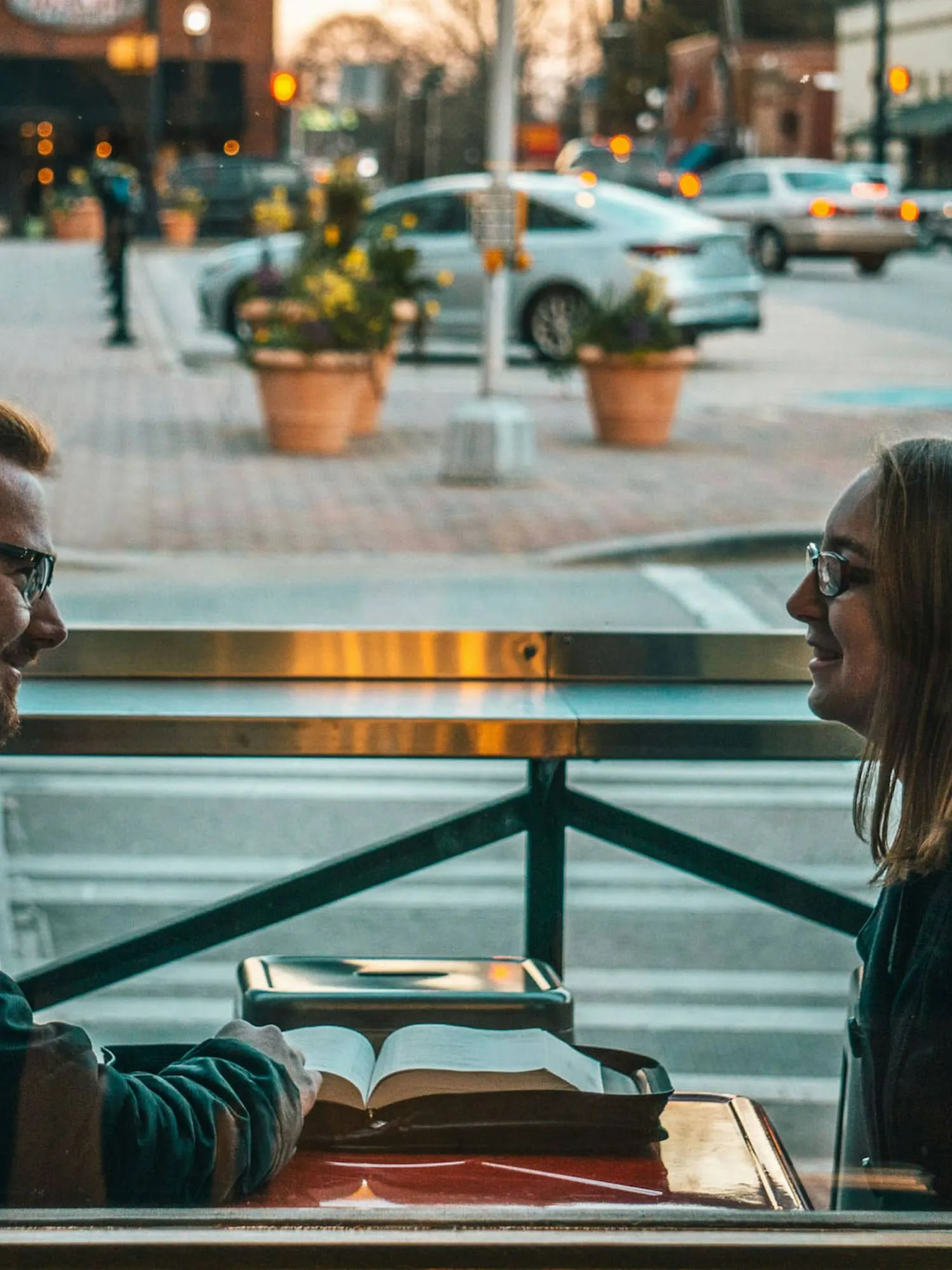 Two people talking over a laptop and notes